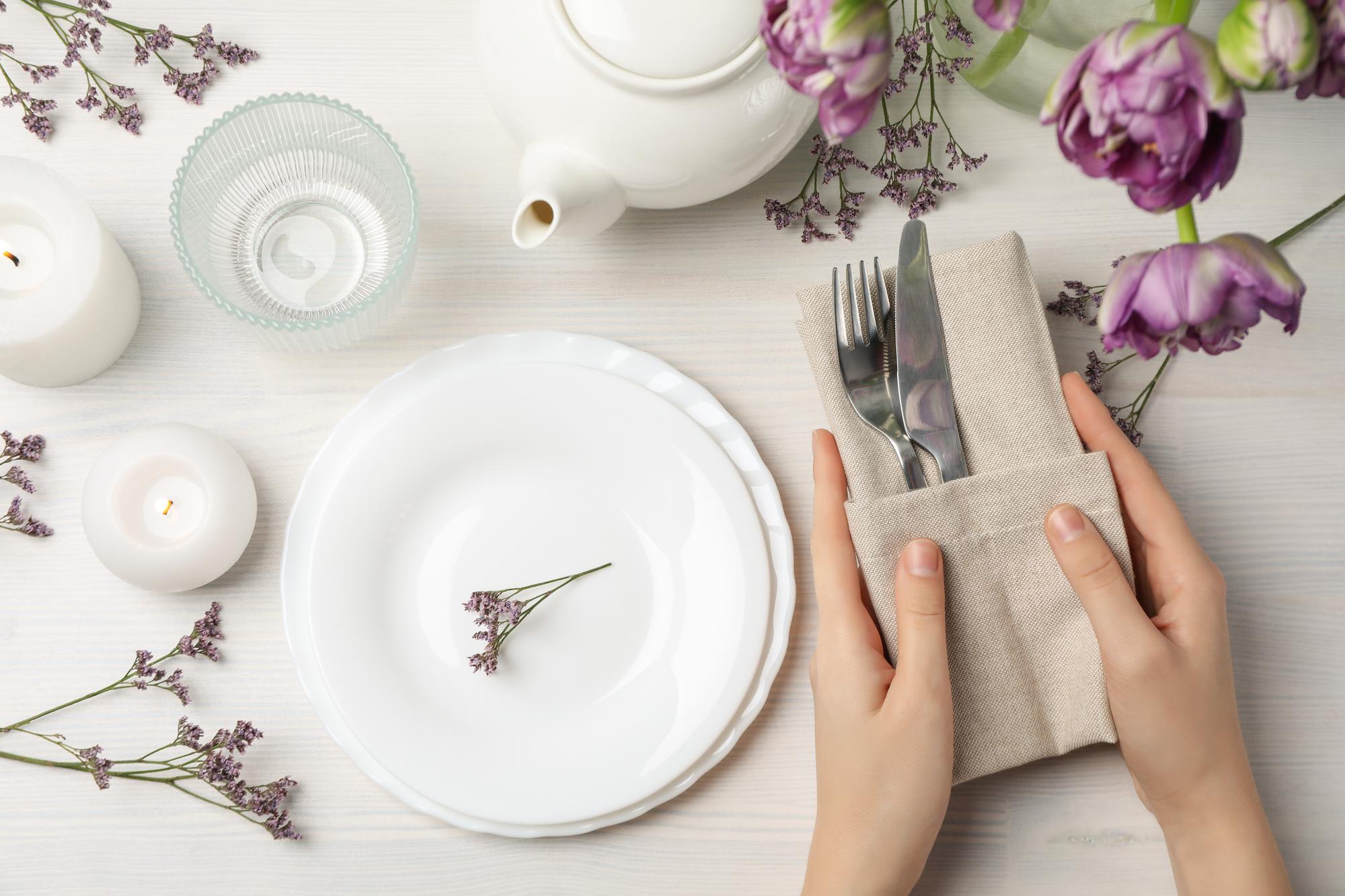 hands arranging plates on a table